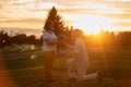 Man kneeling and giving flowers to his wife.