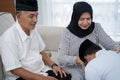 Man kneeling and kiss his parent`s hand asking for forgivness