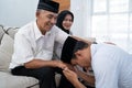 Man kneeling and kiss his parent`s hand asking for forgivness