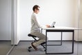 Man on kneeling stool - correct sitting position Royalty Free Stock Photo