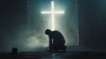 Man kneels before cross, man kneels in prayer in front of cross