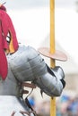 A man knight in helmet with fabric clippings holding a plastic sword