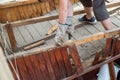 The man knocks an old rotten wooden plank with a hammer