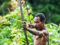 Man Korowai tribe shoots a bow. Tribe of Korowai Kombai , Kolufo.