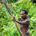 Man Korowai tribe shoots a bow. Tribe of Korowai Kombai , Kolufo.