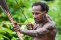 Man Korowai tribe shoots a bow. Tribe of Korowai Kombai , Kolufo.