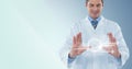 Man in lab coat with white interface and flare between hands against blue background Royalty Free Stock Photo