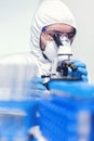 Man laborant in ppe suit using microscope doing research Royalty Free Stock Photo