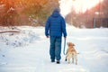 A man with the dog walking along a snow-covered road Royalty Free Stock Photo