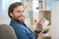 man laid on sofa eating salad Royalty Free Stock Photo