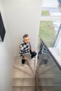 Man with laptop climbing stairs looking at camera Royalty Free Stock Photo