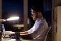 Man with laptop and coffee working at night office Royalty Free Stock Photo