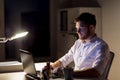 Man with laptop and coffee working at night office Royalty Free Stock Photo