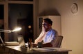 Man with laptop and coffee working at night office Royalty Free Stock Photo