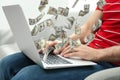 Man with laptop and flying dollar banknotes at home, closeup. People make money online Royalty Free Stock Photo