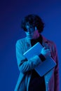 man with laptop in his hands and a jacket portrait, futuristic glasses in blue light, Blue Perennial color, cyber
