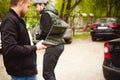 Man with a laptop in parking lot in yard near car is doing manipulations with cyber system Royalty Free Stock Photo