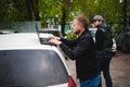 Man with a laptop in parking lot in yard near car is doing manipulations with cyber system Royalty Free Stock Photo