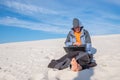 Man with a laptop is sitting in the middle of the desert Royalty Free Stock Photo