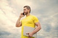 man with laptop speaking on mobile phone on sky background Royalty Free Stock Photo