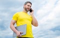 man with laptop speaking on smartphone on sky background. modern life Royalty Free Stock Photo