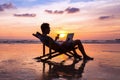 Man with laptop on sunset beach Royalty Free Stock Photo