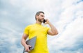 man with laptop talking on phone on sky background Royalty Free Stock Photo
