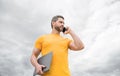 man with laptop talking on phone on sky background Royalty Free Stock Photo