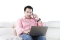 Man with laptop talking on smartphone Royalty Free Stock Photo