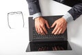 Man with laptop typing on the keyboard. On white table.. Royalty Free Stock Photo