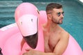 Man in large inflatable pink flamingo