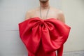 Man with large red ribbon necklace before Genny fashion show, Milan Fashion Week street style