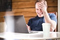 Man laughing while using laptop. Happy smiling guy with computer Royalty Free Stock Photo