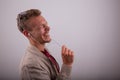 A man laughs while listening to an audio with his earphones, studio shot with a white background Royalty Free Stock Photo