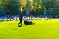 A man with a lawn mower mows grass on the lawn at a country club by the pool. Royalty Free Stock Photo