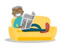 Man laying on the couch and reading a newspaper.