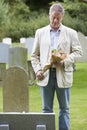 Man Laying Flowers on Grave