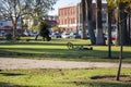 A man laying on the grass next to his bike in Central Park surrounded by lush green trees, buildings and cars parked on the street Royalty Free Stock Photo