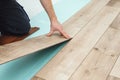 Man laying laminate flooring - closeup on male hands. Worker hands installing timber laminate floor. Easy and quick installation Royalty Free Stock Photo