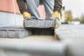 Man laying a paving brick placing it on the sand foundation