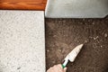 Man is laying quadratic tiles in the garden