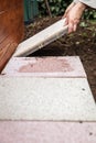 Man is laying quadratic tiles in the garden