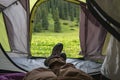 Man is laying in tent in beautiful mountains. Camping in mountains. Tourism hiking concept.