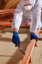 Man laying thermal insulation layer on building