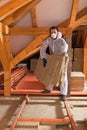 Man laying thermal insulation layer under the roof Royalty Free Stock Photo