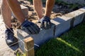 A man lays concrete blocks on a poured foundation, gluing them with mortar. Royalty Free Stock Photo