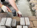 Man lays paving stones on the sand, restoring a patch of damaged pavement in the yard of a house Royalty Free Stock Photo