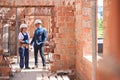 Man lead architect walking along construction site with workwoman Royalty Free Stock Photo