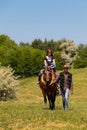 Man leading a horse with young woman and her child ride Royalty Free Stock Photo