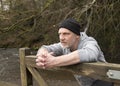 Man leaning against an old wooden gate outdoors Royalty Free Stock Photo